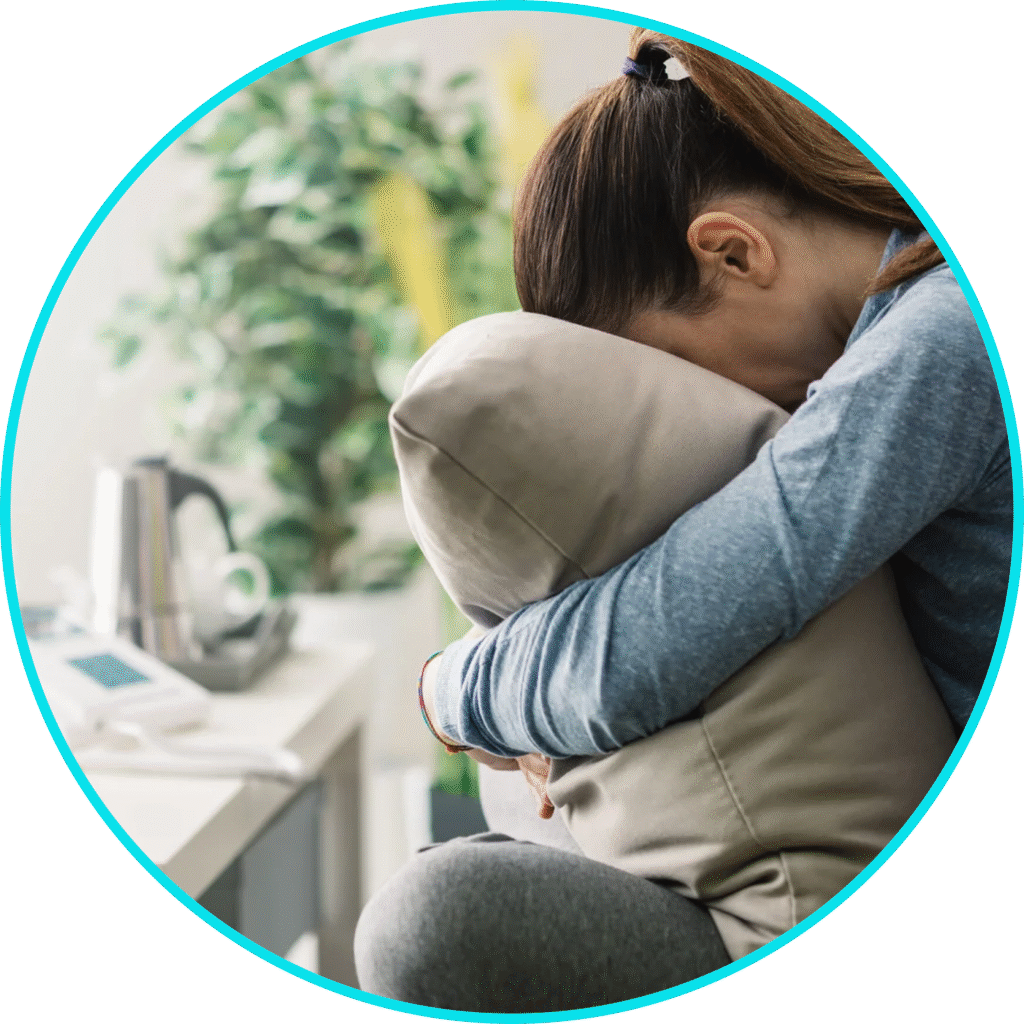 A woman holding her pillow sitting down
